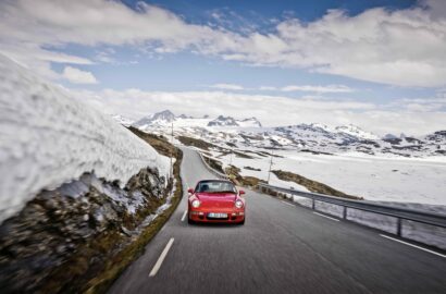 Rød bil i norsk fjellandskap.