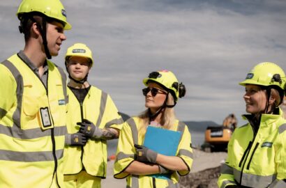 four people at a building site in yellow clothes